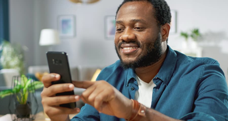 Man in his home using a home security app on his phone